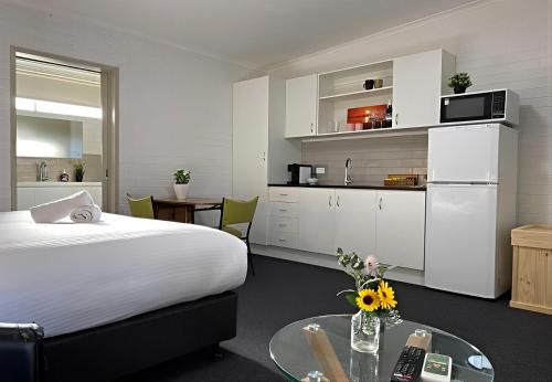 Un dormitorio con una cama y una mesa y una cocina. en Sea Lake Motel, en Sea Lake
