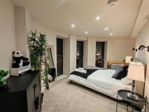 a bedroom with a bed and a desk and some windows at Luxury 2-Bedroom Penthouse with Stunning Views and Parking - Leeds City Centre in Leeds