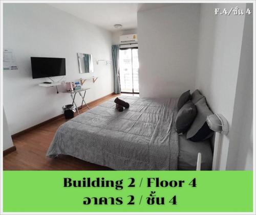 a bedroom with a bed and a flat screen tv at HOMEY-Sleepy Don Mueang Airport Hostel in Bangkok