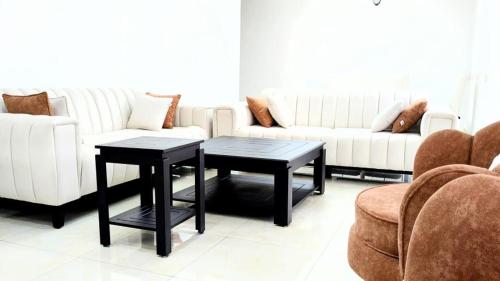 a living room with two tables and a couch at Kigali Nice Apartment in Kigali