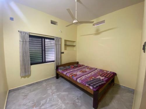 ein Schlafzimmer mit einem Bett und einem Deckenventilator in der Unterkunft RDS Homestay in Honāvar