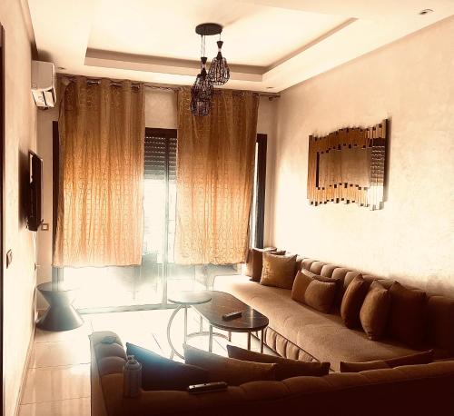 a living room with a couch and a table at Appartement Moderne et Confortable in Bouznika