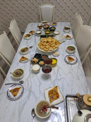 a long table with plates of food on it at Guest House Ormon in Ak-Muz
