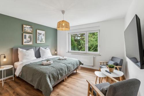 a bedroom with a large bed and a window at Modernes 6-Betten-Apartment mit Balkon und Parkplatz - zentrale Lage in Aalen