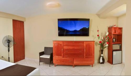a bedroom with a dresser with a tv on it at Hostel Esperanza in Lima