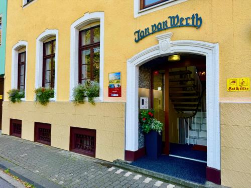 a yellow building with the entrance to a restaurant at Hotel Jan van Werth in Koblenz