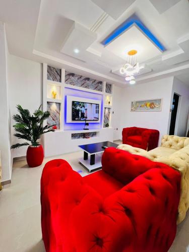 a living room with a red couch and a tv at The BMC Place in Fatade