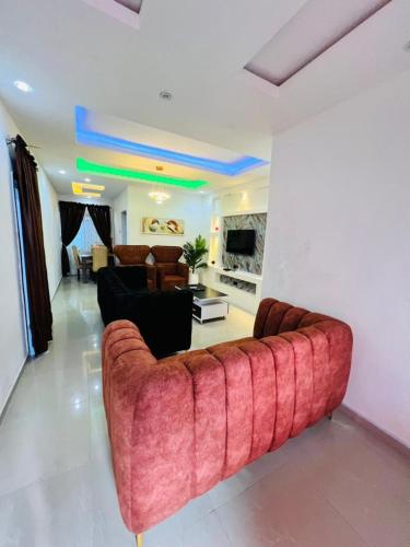 a living room with a large red couch in a room at The BMC Place in Fatade