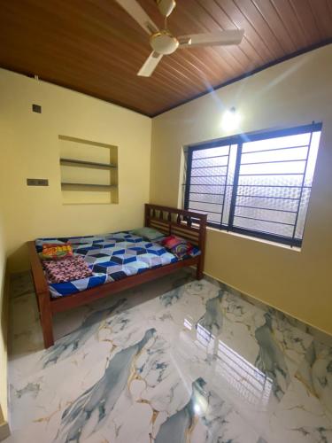 a bedroom with a bed with a map on the floor at RDS Homestay in Honāvar