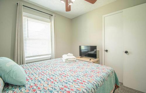 a bedroom with a bed and a television at Turtle Time! in Oak Island