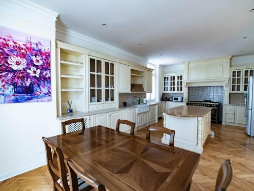 une cuisine avec des armoires blanches et une table en bois dans l'établissement La Finestra sul Corso, Gorizia, à Gorizia