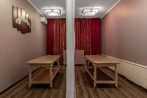 a room with two stools in front of a red curtain at Sonata Hotel in Kyiv