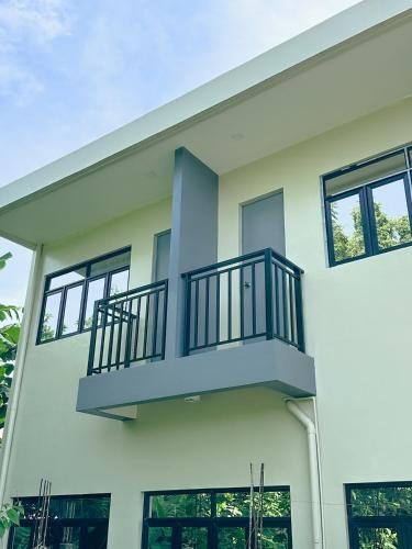 a white house with a balcony at Casa Issabella Cozy & Stylish Studio in Sorsogon in Sipak