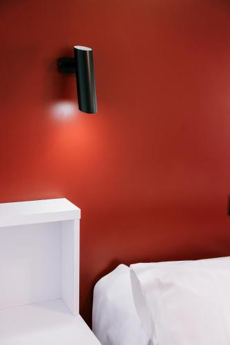 a black light on a red wall next to a bed at Hospedium Hotel Continental in Mojácar
