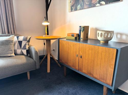 a living room with a chair and a table at Herzogskelter Hotel & Restaurant in Güglingen