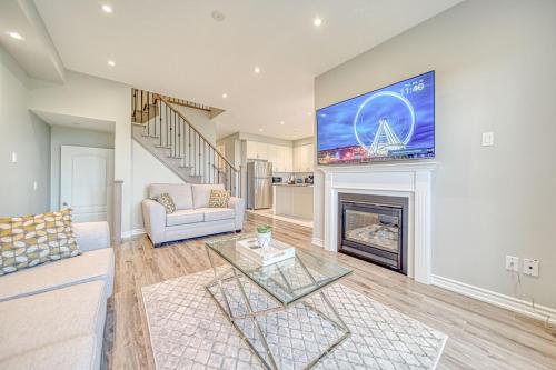 a living room with a couch and a fireplace at Spacious 3BR Townhome Near Casino & Thermea Spa in Ajax