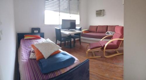a room with a bed and a couch and a desk at ATLAS - San Telmo in Buenos Aires