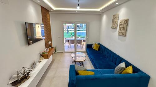 a living room with a blue couch and a table at Nouvel appartement élégant à Cabo - Vue sur la piscine et proche de la plage in Cabo Negro