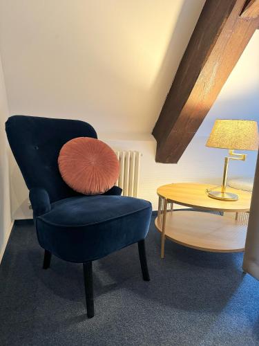 a blue chair and a table with a lamp at Herzogskelter Hotel & Restaurant in Güglingen
