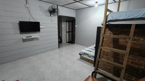 a room with a bunk bed and a flat screen tv at Aleesa Roomstay & Hotel in Pasir Puteh