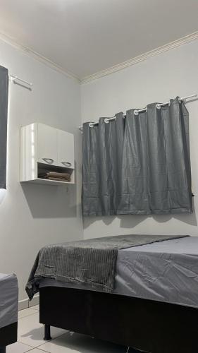 ein Schlafzimmer mit einem Bett mit einem grauen Vorhang in der Unterkunft Lar Aconchego 2 in Palmas