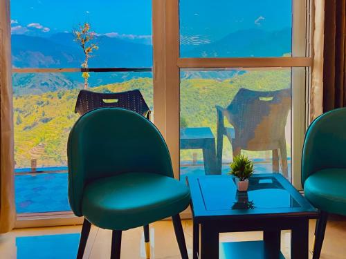 a room with two chairs and a table and a window at Pinerock Resort ! Luxury! Mountain View! Open Terrace ! Cafeteria in Mussoorie