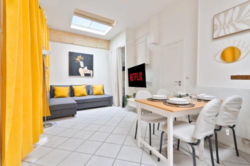 a living room with a table and chairs and a couch at Studio Appartement Quartier Musée du Louvre 3 Free Netflix in Paris