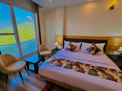 a bedroom with a large bed and a large window at The Pine Woods A Luxury Resort in Mussoorie Rooftop Restro in Mussoorie