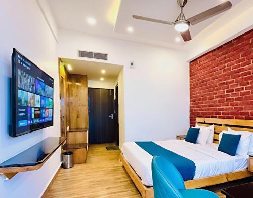 a bedroom with a bed and a tv on a wall at The Pine Woods A Luxury Resort in Mussoorie Rooftop Restro in Mussoorie