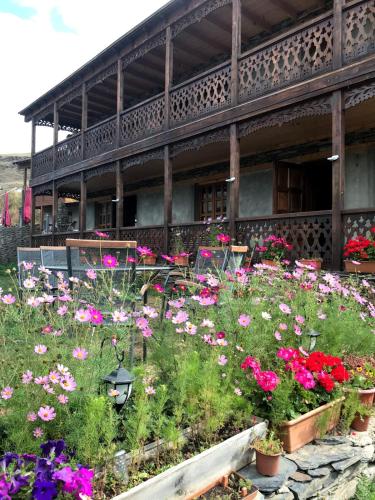 a garden of flowers in front of a building at Guest House Shina in Omalo
