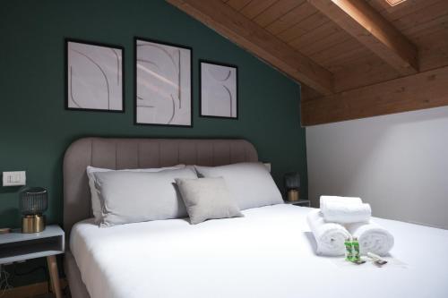 a bedroom with a white bed with four pictures on the wall at CharmEscape OldTown - 6 min walk to BerninaExpress in Tirano