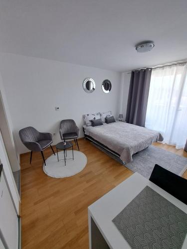 サラエボにあるMia Apartmentのベッドルーム1室(ベッド1台、椅子2脚付)