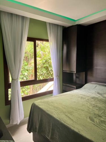 a bedroom with a bed and a large window at Amerigo Vespucci Mar e Ceu in Morro de São Paulo