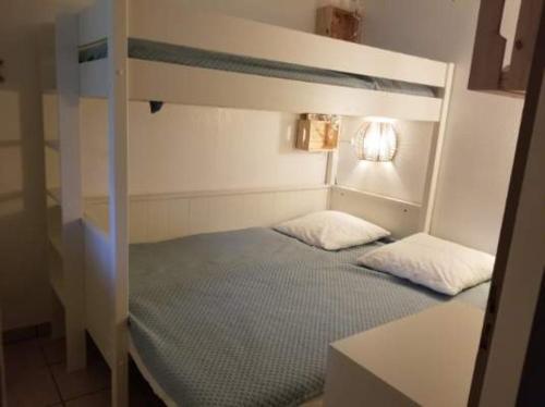 ein Schlafzimmer mit einem Etagenbett mit zwei Kissen in der Unterkunft Appartement cosy sous pinède lac de Biscarrosse rénové in Biscarrosse