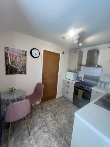 a kitchen with a table and a clock on the wall at Holiday home Irton in Seamer