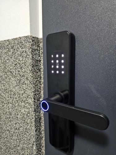 a black refrigerator with a blue button on it at Apartamenty SWAN in Gliwice
