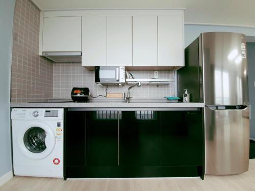 a kitchen with a washing machine and a refrigerator at Gunsan Little Prince Condo in Gunsan