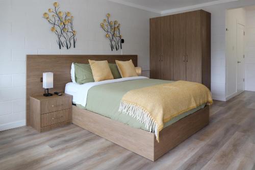 a bedroom with a large bed with a wooden headboard at Stay Inn Muskoka in Gravenhurst