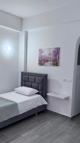 a bedroom with a bed and a picture on the wall at Sevilia Rooms in Qeparo