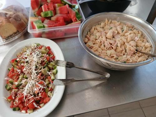 eine Schüssel mit Nudeln und eine Schüssel mit Obst in der Unterkunft Laganas Beach Hotel in Laganas