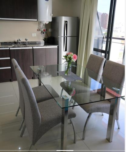 a glass table and chairs in a kitchen at Departamento centro Carlos Paz con pileta in Villa Carlos Paz