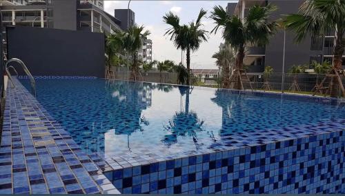 a large blue swimming pool with palm trees on a building at Flora Rozel Homestay, Bangi in Kajang