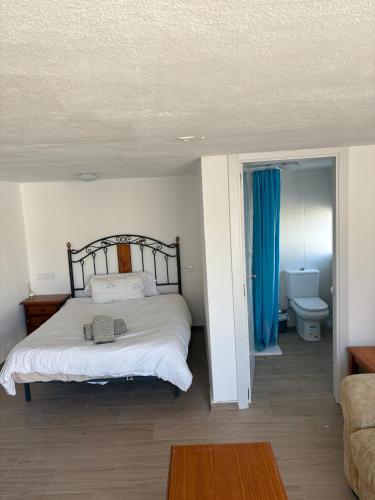 a bedroom with a bed and a bathroom with a toilet at Casita Malaga Airport in Cártama