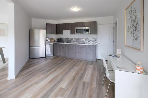 a large kitchen with white walls and wooden floors at Stay Inn Muskoka in Gravenhurst