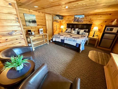 a bedroom with a bed and chairs in a cabin at Mountain View Lodge & Cabins in Hill City