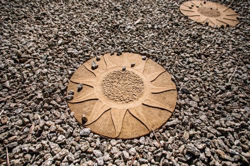 a wooden circle with a sun on the ground at Deveron Valley Cottages in Marnoch