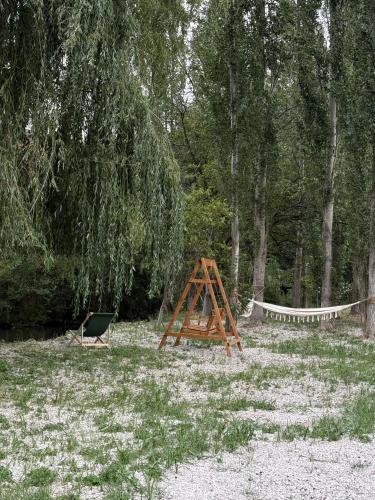 a wooden frame and a hammock in a field at Parpi Riverside in Pʼarpi