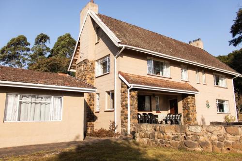 an old house with a stone wall at Ondini Guest House in Winterton