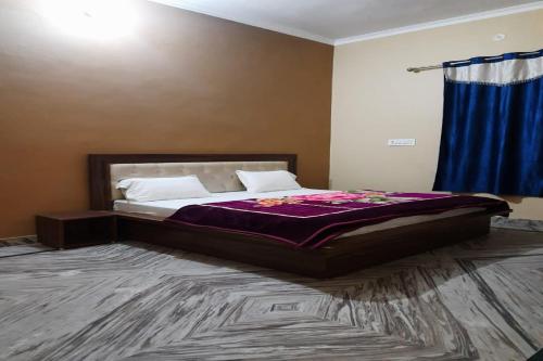 a bedroom with a bed with a purple comforter at Hotel O Ocean's 11 in Daurāla