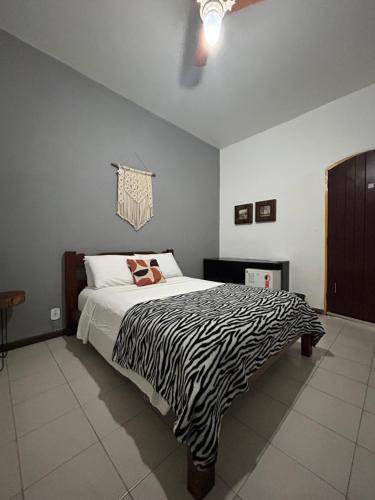 a bedroom with a zebra print bed in a room at MAI Chameguin Hospedagens Paraty in Paraty